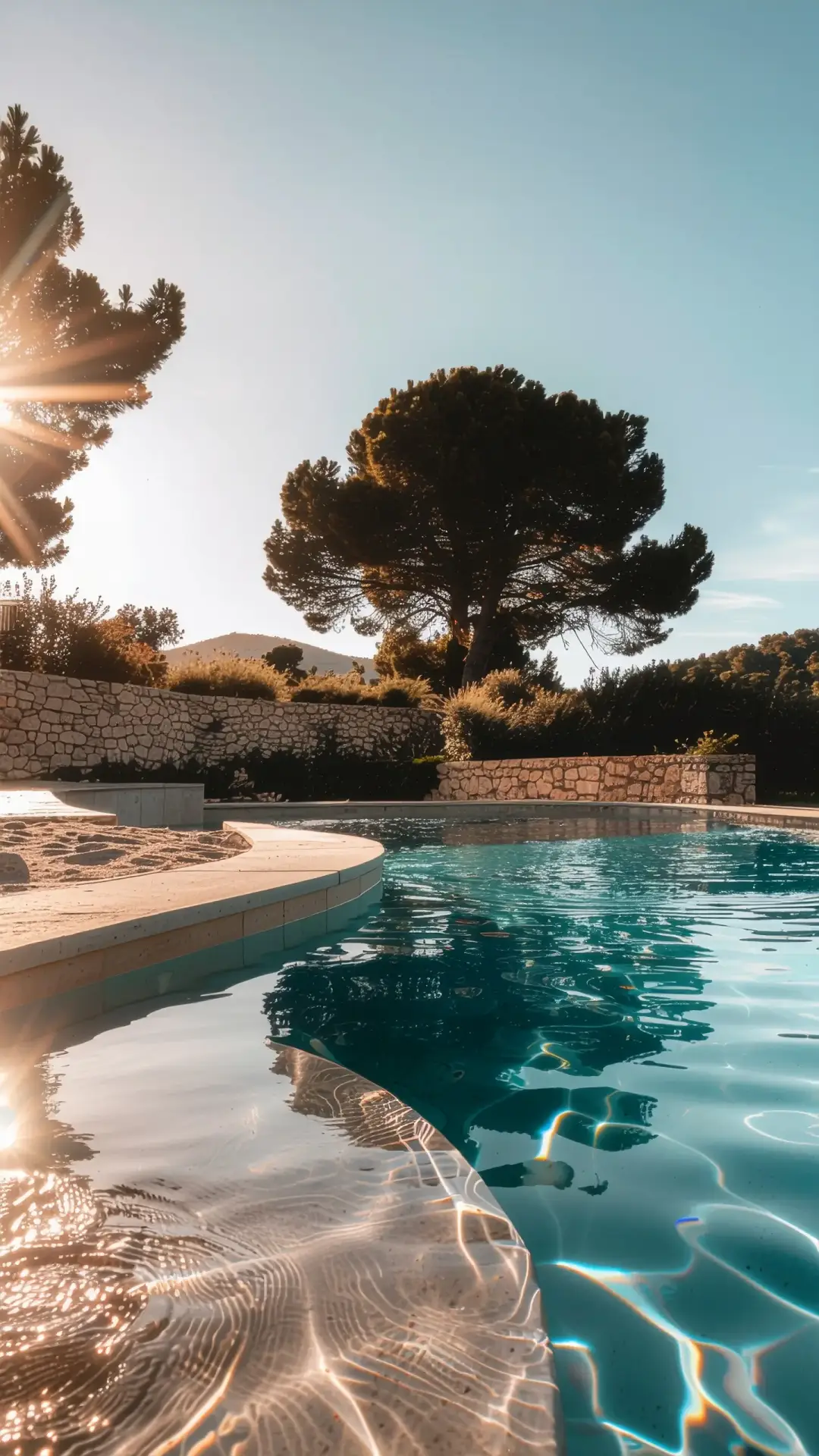 Piscine en béton sur mesure réalisée à Avignon avec margelles en pierre et jardin paysager